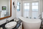 Master bathroom with a soaking tub and ocean views.